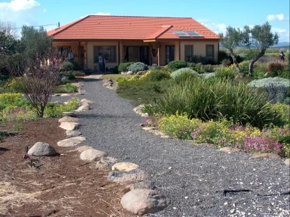 גינה בשרונה שילוב של סלעי בזלת מקומית ושתילה תוך כדי שמירה של  הנוף